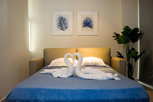 two white swans sitting on top of a bed at Apartamento en Sognare in Encarnación