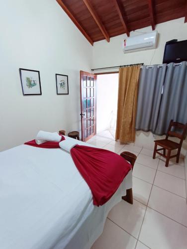 a bedroom with a bed with a red blanket on it at Brisa da Serra Hotel Pousada Pirenopolis in Pirenópolis