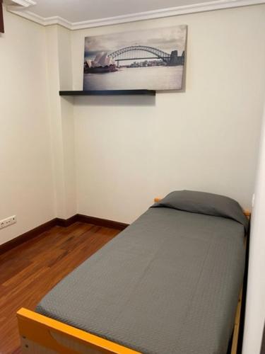 un letto in una camera con una foto sul muro di APARTAMENTOS URDAIBAI 7 a Bermeo