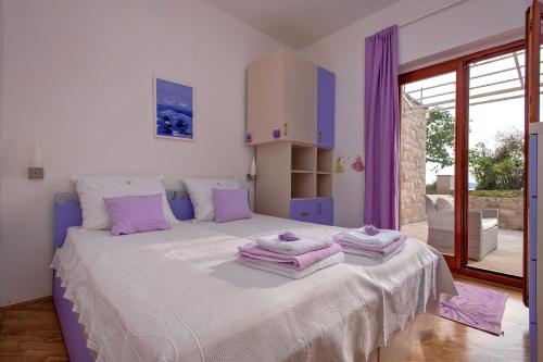 a bedroom with a large bed with purple accents at Apartment Hvar 11427a in Hvar