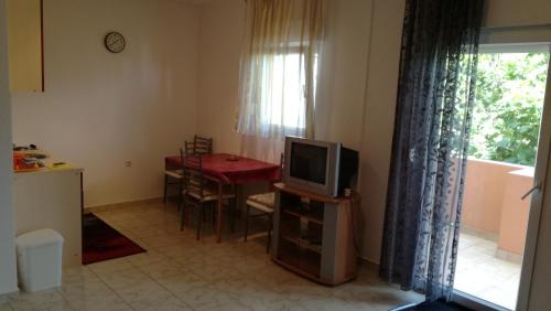 a living room with a tv and a table with a dining room at Studio Barbat 11472a in Rab