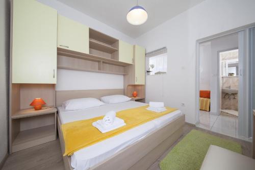 a bedroom with a large white bed with towels on it at Apartment Tucepi 11486a in Tučepi
