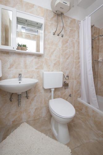 a bathroom with a toilet and a sink at Apartment Tucepi 11486a in Tučepi