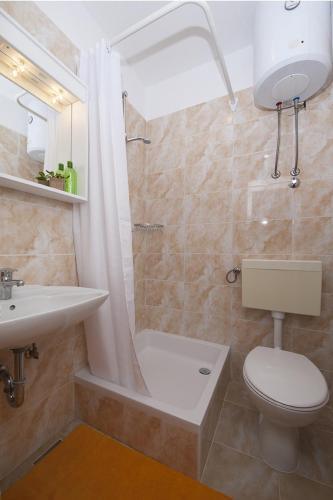a bathroom with a toilet and a sink and a shower at Apartment Tucepi 11486a in Tučepi