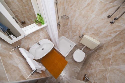 a bathroom with a white toilet and a sink at Apartment Tucepi 11486a in Tučepi
