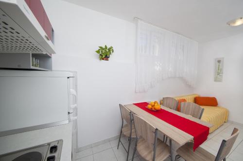 a kitchen with a table with chairs and a couch at Apartment Tucepi 11486a in Tučepi
