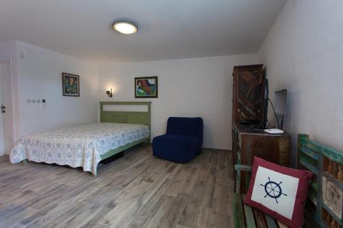 a bedroom with a bed and a blue chair at Apartments with a parking space Kornic, Krk - 11506 in Kornić