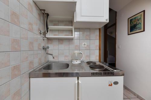 małą kuchnię ze zlewem i kuchenką w obiekcie Apartment Sumpetar 11462a w mieście Jesenice