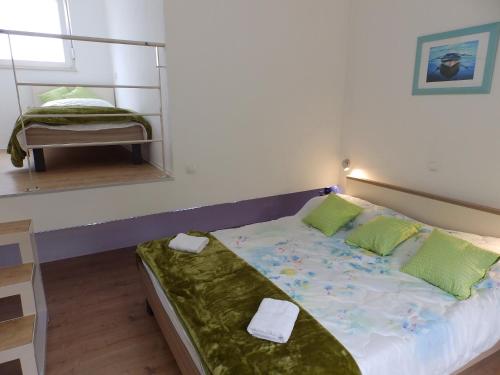 1 dormitorio con cama con almohadas verdes y espejo en Apartments by the sea Savar, Dugi otok - 11540 en Brbinj