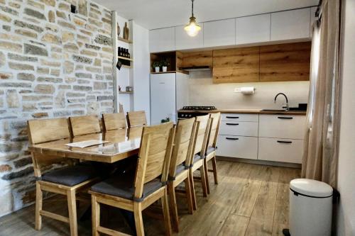 eine Küche und ein Esszimmer mit einem Holztisch und Stühlen in der Unterkunft Secluded fisherman's cottage Cove Donje More, Pasman - 11515 in Tkon