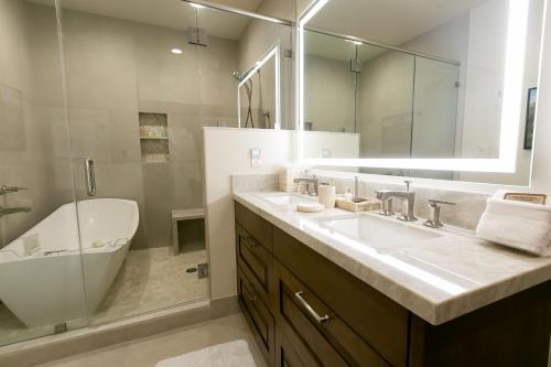 uma casa de banho com um lavatório, um espelho e uma banheira em Sultan Studio Loft Hotel Room em Park City