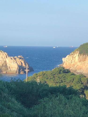a view of the ocean from a hill with a cross at Dongyin Homestay連江縣民宿054號 in Dongyin