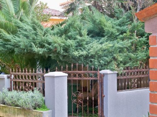 a fence with a pine tree behind it at Apartments by the sea Novalja, Pag - 11512 in Novalja
