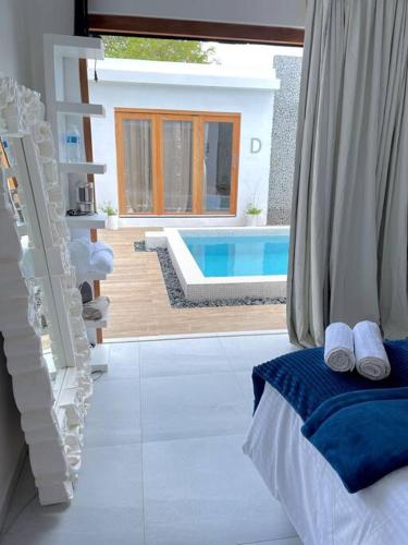 a room with a bed and a swimming pool at Moringa Resort - Studio B with Pool, open Air Shared Shower Bath in Willemstad
