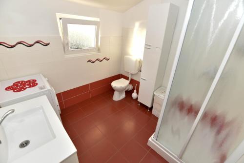 a small bathroom with a toilet and a shower at Apartments by the sea Rtina - Miletici, Zadar - 11548 in Ražanac