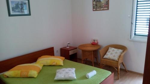 ein Schlafzimmer mit einem Bett, einem Tisch und einem Stuhl in der Unterkunft Apartments by the sea Drvenik Donja vala, Makarska - 11553 in Drvenik
