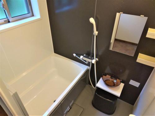 a bathroom with a bath tub and a sink at Nikko Cottage Yurt in Nikko