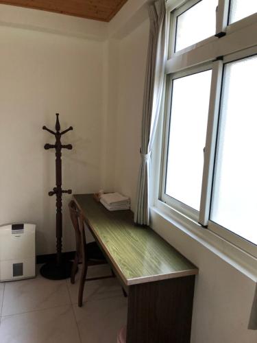 Zimmer mit einem Holzschreibtisch und einem Fenster in der Unterkunft Dongyin Homestay連江縣民宿054號 in Dongyin/