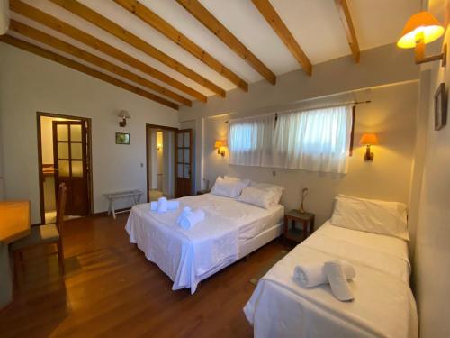 une chambre avec deux lits avec des draps blancs dans l'établissement La Maison Gerber, à Río Colorado