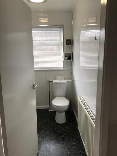 a bathroom with a toilet and a tub and a window at The Bungalow, Lingdale in Lingdale