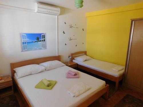 two beds in a room with yellow and white at Apartments by the sea Drace, Peljesac - 11502 in Janjina