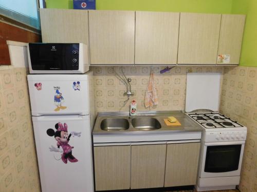 a small kitchen with a white refrigerator and a sink at Apartments by the sea Drace, Peljesac - 11502 in Janjina