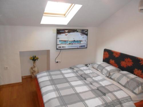a bedroom with a bed and a tv on the wall at Apartments by the sea Senj - 11606 in Senj