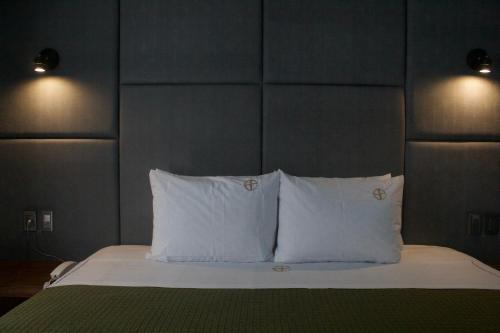 a bed with two white pillows and a headboard at Hotel Grand One Plaza in Tijuana