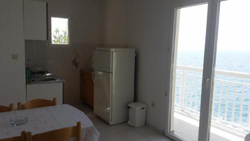 a kitchen with a refrigerator and a table and a window at Apartment Sveta Nedilja 11433a in Jelsa