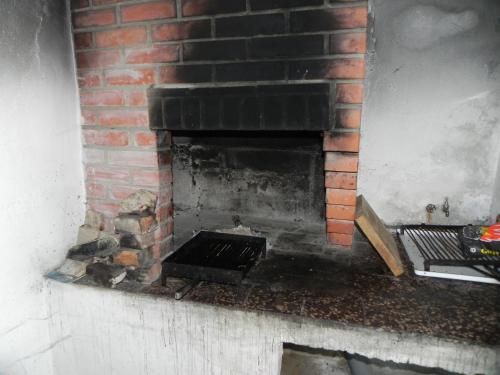 a brick fireplace with a grate in it at Apartment Sveta Nedilja 11433c in Sveta Nedelja