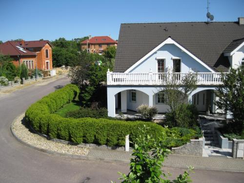 a white house with a balcony on a street at Homestay Kuchařovice in Kuchařovice