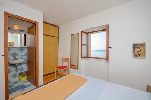 1 dormitorio con cama, lavabo y ventana en Apartment Brela 11552a, en Brela