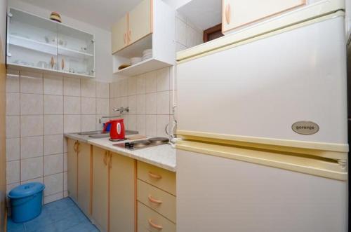 una pequeña cocina con fregadero y nevera. en Apartment Brela 11552a, en Brela