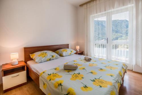 a bedroom with a bed and a large window at Apartments with a parking space Trpanj, Peljesac - 11545 in Trpanj