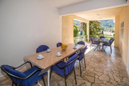 a dining room with a wooden table and blue chairs at Apartments with a parking space Trpanj, Peljesac - 11545 in Trpanj