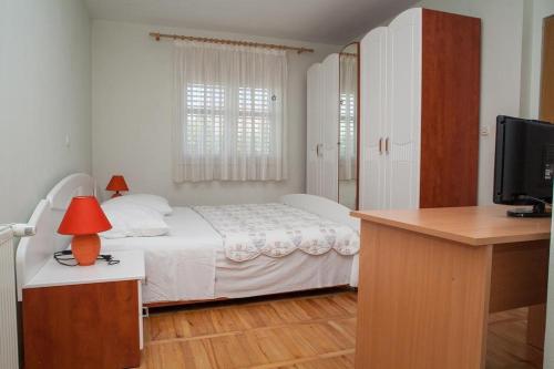 1 dormitorio con 1 cama y escritorio con TV en Apartments by the sea Sukosan, Zadar - 12313, en Sukošan