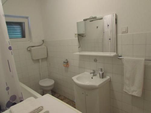 ein weißes Badezimmer mit Toilette und Waschbecken in der Unterkunft Rooms with a parking space Sibenik - 13739 in Šibenik