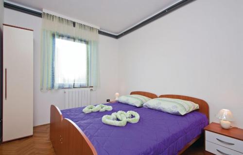 a bedroom with a purple bed with two towels on it at Apartments with a parking space Fazana - 13761 in Marana