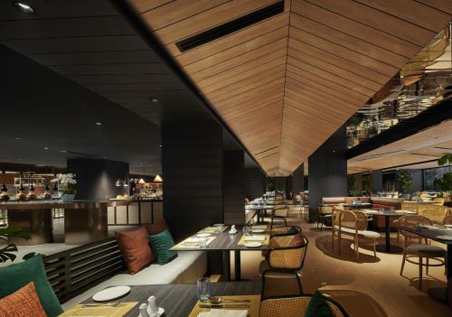a restaurant with tables and chairs and a bar at PARKROYAL COLLECTION Kuala Lumpur in Kuala Lumpur