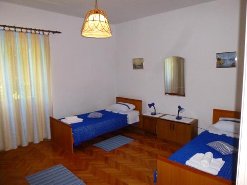 Zimmer mit 2 Betten und einem Spiegel in der Unterkunft Apartments by the sea Ugljan - 13764 in Ugljan