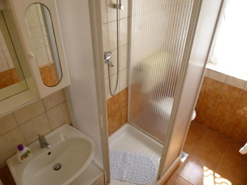 ein Bad mit einer Dusche und einem Waschbecken in der Unterkunft Apartments by the sea Ugljan - 13764 in Ugljan