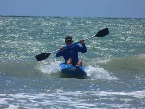 a man is sitting on a kayak in the water at Pousada Casa Azul do Piauí in Luis Correia
