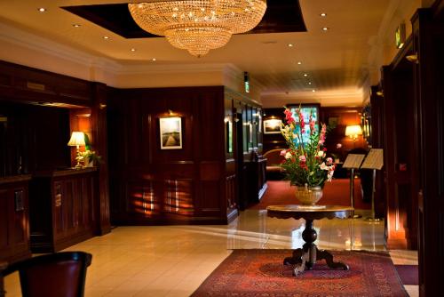 a lobby with a table and a vase of flowers at Harvey's Point in Donegal