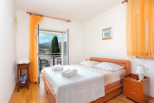 um quarto com uma cama com duas toalhas em Apartments by the sea Seget Vranjica, Trogir - 13771 em Trogir