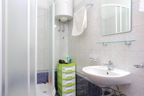 uma casa de banho com um lavatório, um WC e um espelho. em Apartments by the sea Seget Vranjica, Trogir - 13771 em Trogir