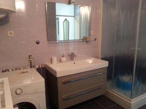 a bathroom with a sink and a washing machine at Apartments by the sea Omis - 13796 in Omiš