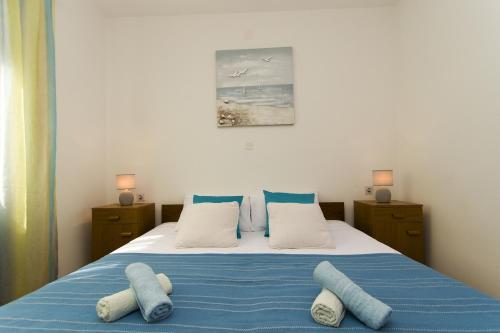 1 dormitorio con 1 cama con sábanas y almohadas azules en Seaside holiday house Cove Gradina, Korcula - 13803, en Vela Luka