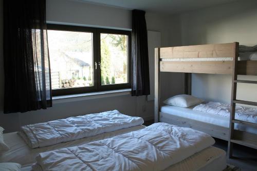 1 Schlafzimmer mit 2 Etagenbetten und einem Fenster in der Unterkunft Auf der Platte 1 in Winterberg