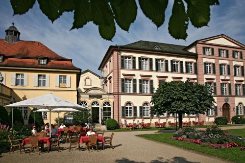 a group of people sitting at a table in front of a building at Badhotel Bad Brückenau in Staatsbad Brückenau