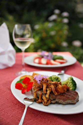 a table with two plates of food and a glass of wine at Badhotel Bad Brückenau in Staatsbad Brückenau